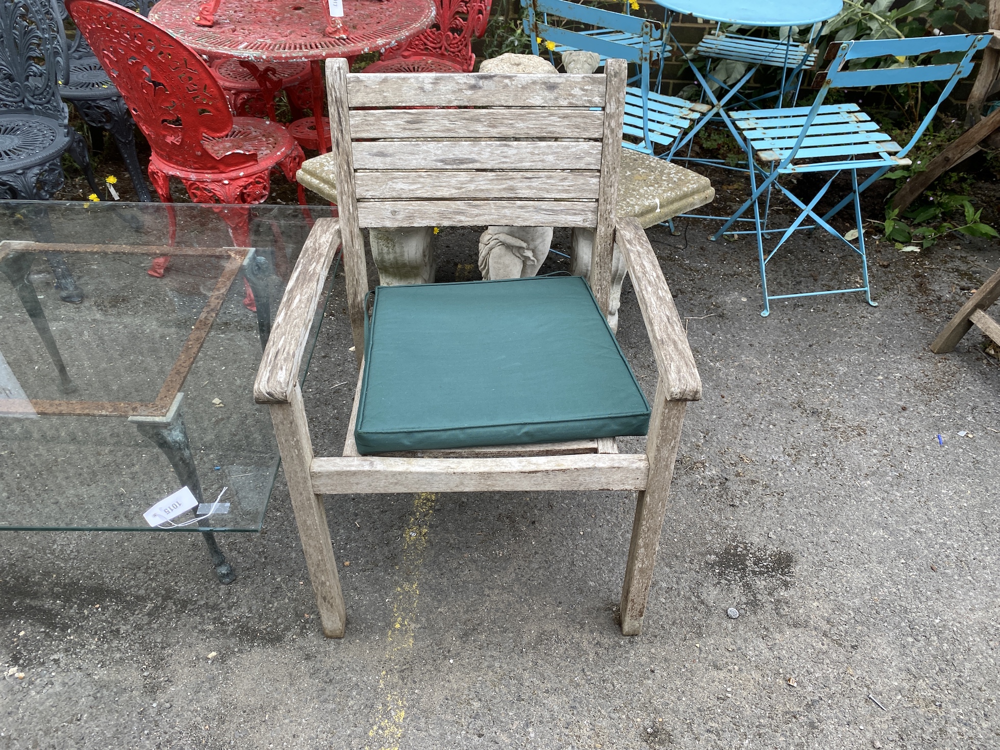 A square glass top cast metal garden table on a metal base, length 100cm, height 44cm together with a pair of teak elbow chairs